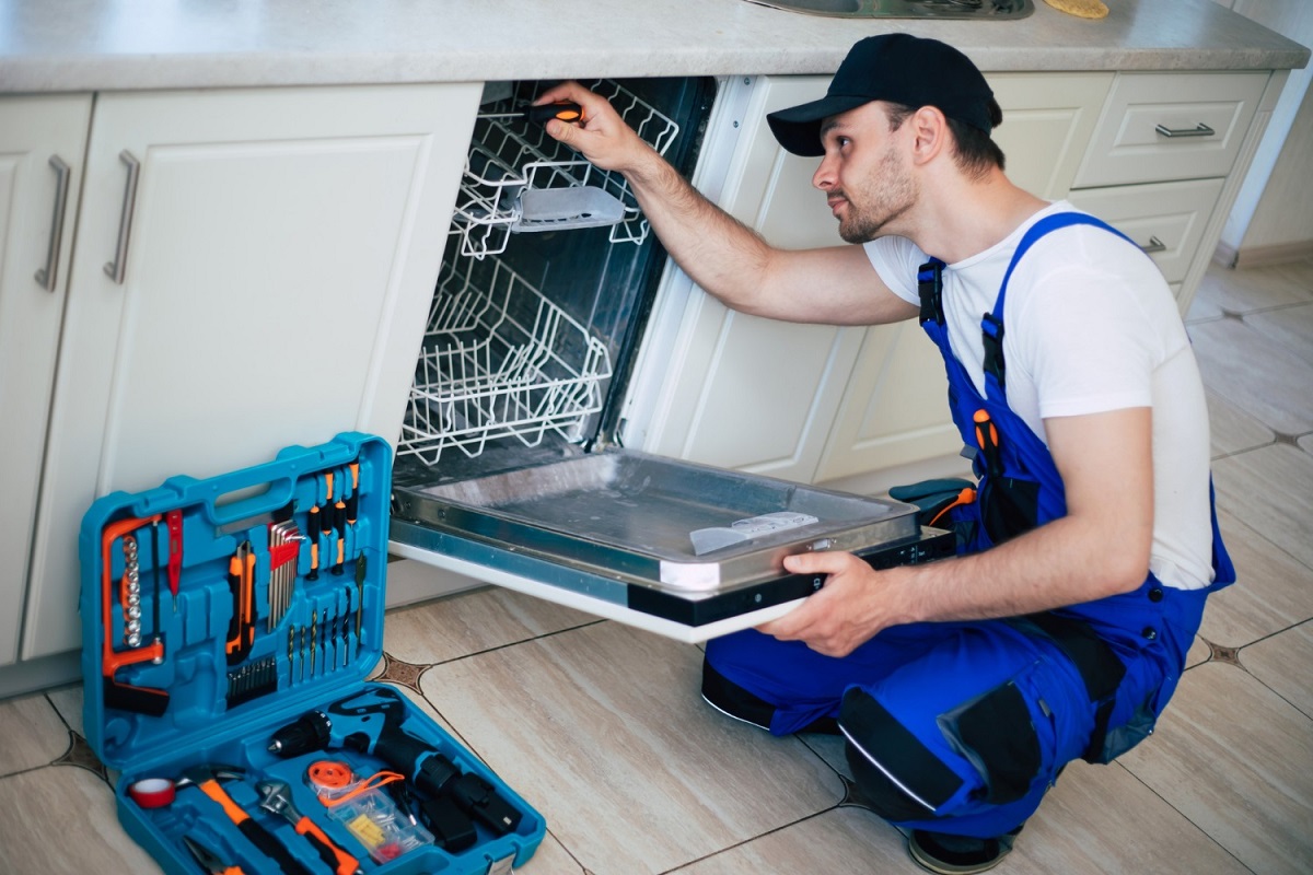 technician repairing a Cove dishwasher filter system in a Los Angeles home kitchen